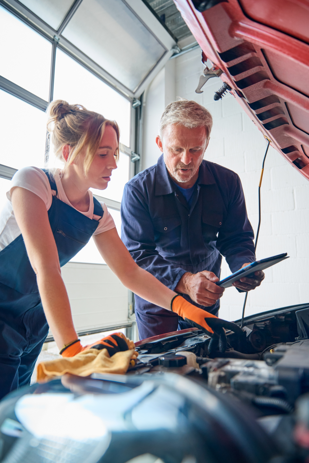 Chica mecánico comprobando una reparación de motor de un coche