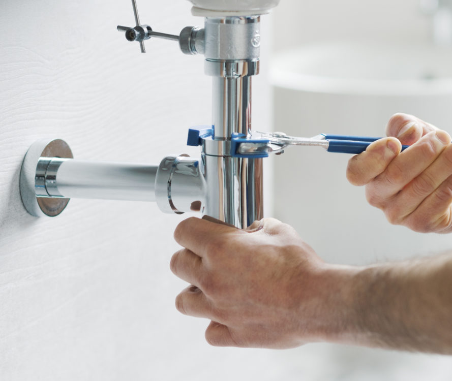 Fontanero ajustando sifón de un lavabo